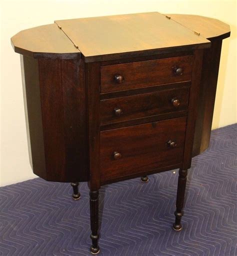 A Small Wooden Cabinet With Three Drawers