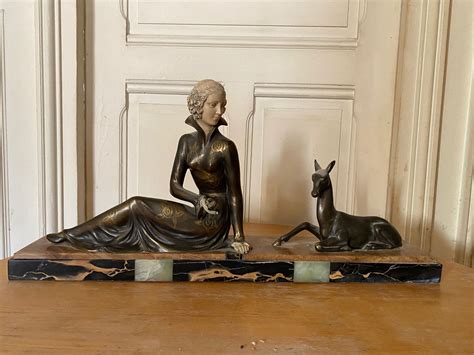 sculpture en régule et plâtre patiné représentant une jeune femme assise donnant à manger à une