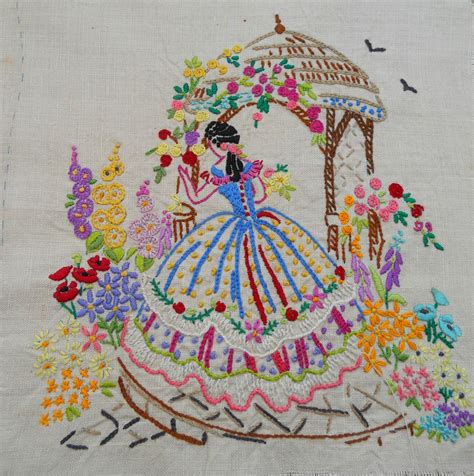 A Vintage Embroidery On Linen Of A Lady In Crinoline Dress In A Flower Garden With A Rose Arbour