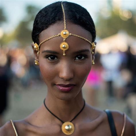 A Woman Wearing A Gold Head Piece And Necklace