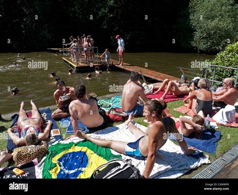 People Sunbathing And Mixed Swimming At Ahampstead Heath Pond On A Sweltering Hot Day In Summer