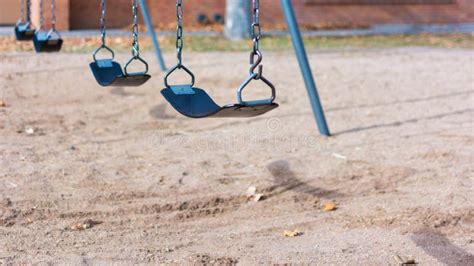 An Empty Row Of Swings On A Deserted Playground Stock Image Image Of