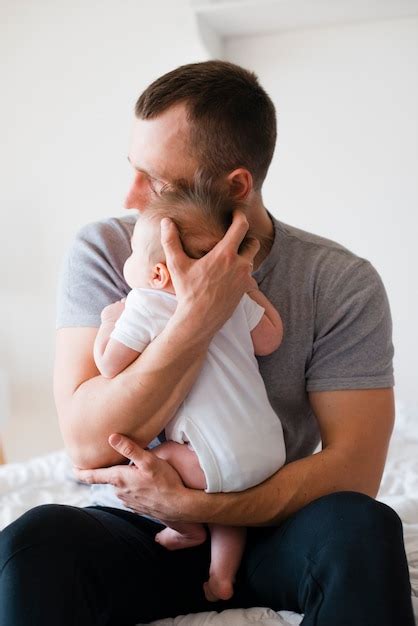 Papá Abrazando Al Bebé Con Suavidad Y Cuidado Foto Gratis