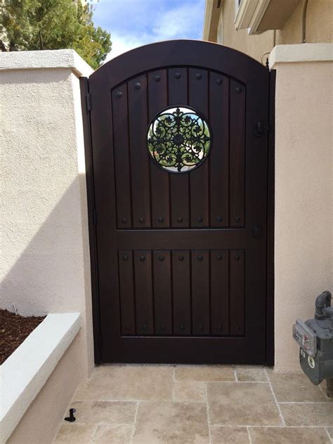 Custom Wood Gate With Metal Grill And Decorative Clavos By Garden