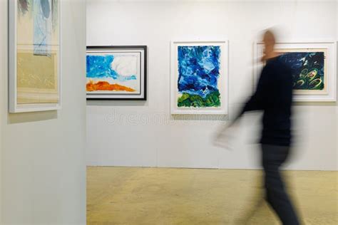 Man Walking And Admiring Paintings In A Modern Art Gallery Editorial