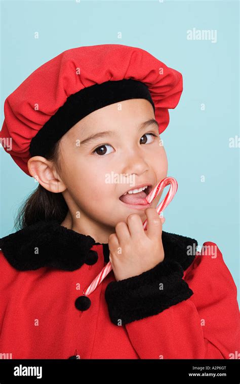 Girl Eating Candy Cane Stock Photo Alamy