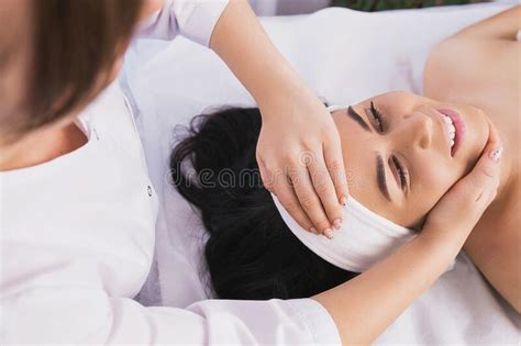 Above Photo Of Cosmetologist Making Facial Beauty Massage Treatment For Relaxed Young Woman Face