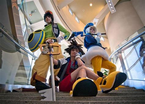 Four People Dressed In Costumes Sitting On Some Stairs
