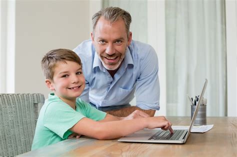 Padre E Hijo Usar La Computadora Portátil En El Escritorio Foto Premium