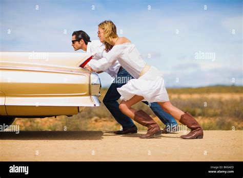 Couple Pushing A Car Stock Photo Alamy