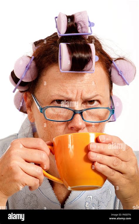 Grumpy Middle Aged Woman With Hair Rollers Drinking Coffee Stock Photo