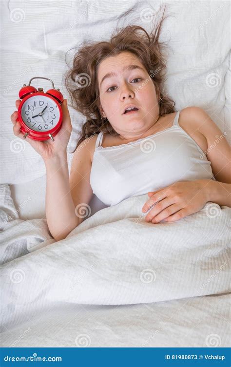 Young Woman Is Waking Up She Oversleep And Is Shocked Stock Image