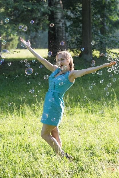 Premium Photo A Girl Makes Big Soap Bubbles In The Park
