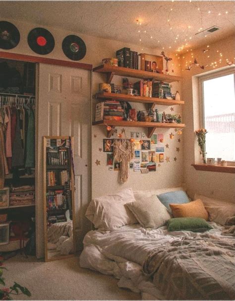 a bed sitting under a window next to a book shelf filled with lots of books
