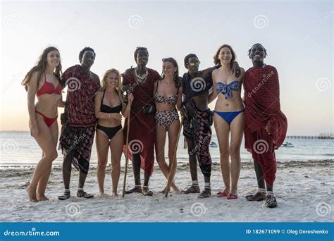 African Men Masai With A European Girls Take Pictures On The Tropical Beach Near The Ocean On
