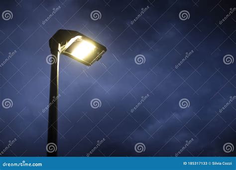 Street Lamp Lit At Twilight With Rain Falling Stock Image Image Of