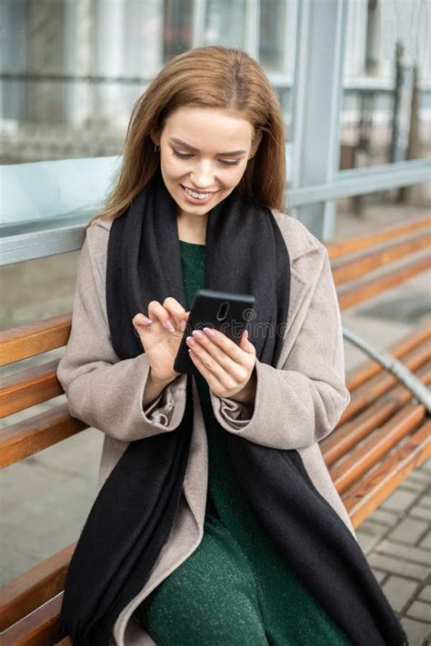 Girl Sitting At Bus Stop And Watching In The Phone Stock Image Image
