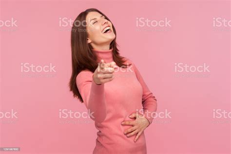 Extremely Excited Happy Woman Laughing Out Loud Holding Her Belly And Pointing Finger At Camera