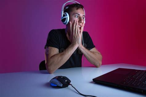 Tired Gamer Wearing Headphones Playing Video Games On Computer In A