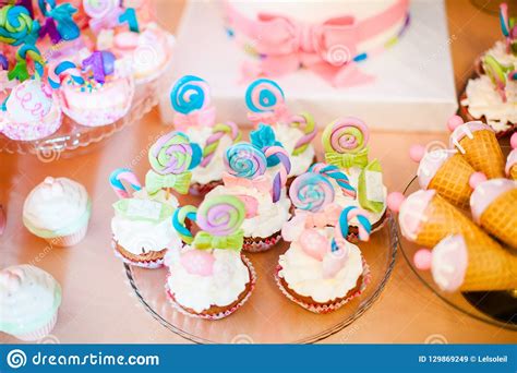 Pink And Blue Cupcakes With Colored Lollypops For Candy Bar Stock Image