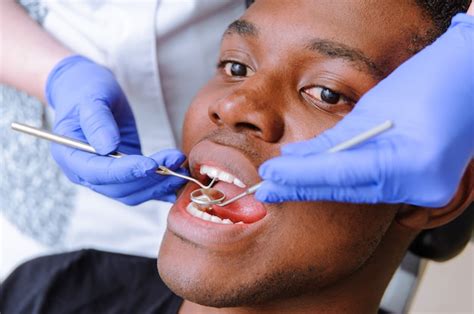 Premium Photo African Male Patient Getting Dental Treatment In Dental