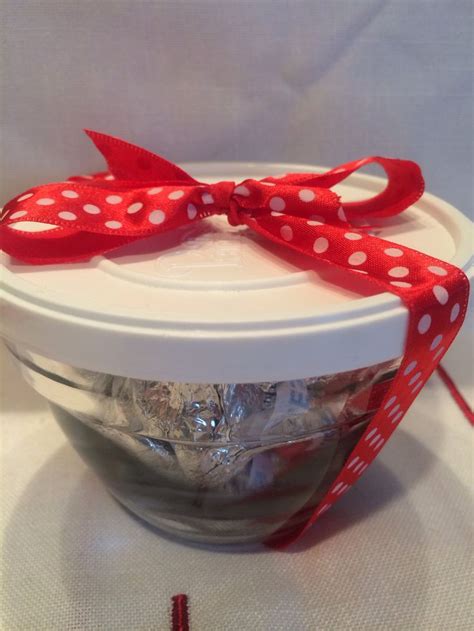 A Bowl Filled With Candy Wrapped In Red And White Polka Dot Ribbon