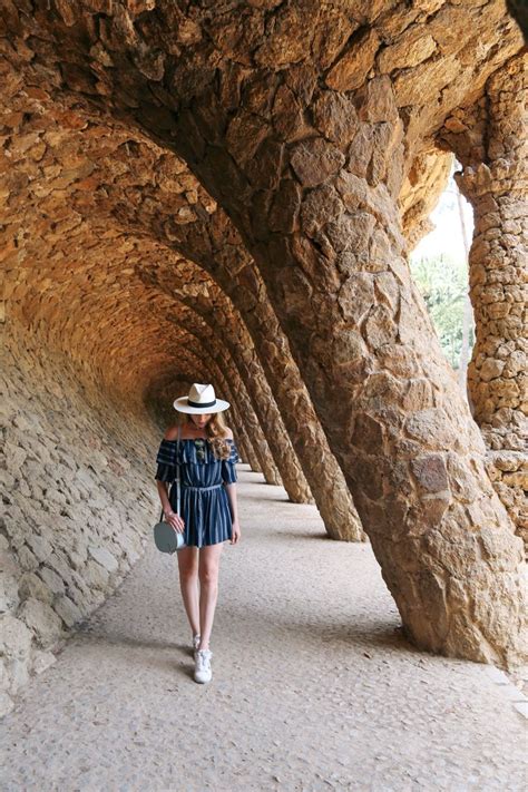 A Woman Wearing A Hat Walking Down A Stone Walkway