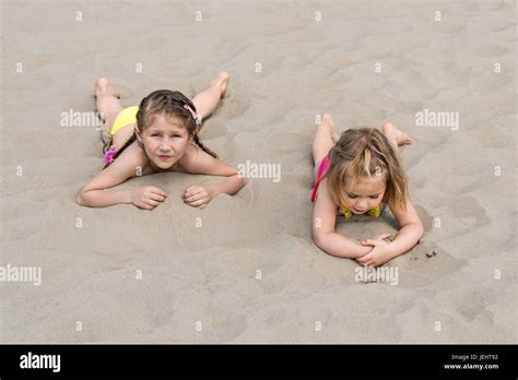 Zwei Kleine Mädchen Liegen Auf Ihren Bäuchen Auf Weißen Meeressand