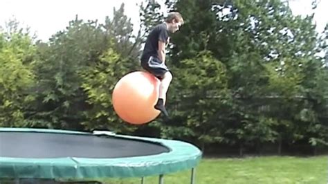 Guy Holding Yoga Ball Jumps Off Roof To Trampoline Jukin Media Inc