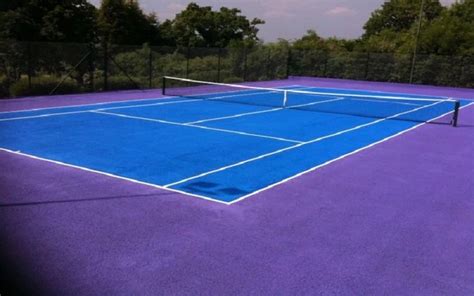A Blue Tennis Court With Trees In The Background