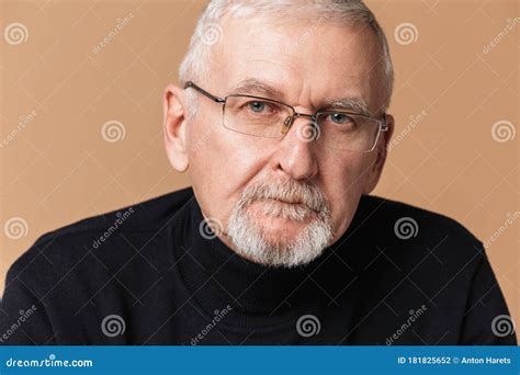 Old Handsome Man With Gray Hair And Beard In Eyeglasses And Sweater Thoughtfully Looking In