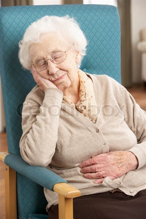 Senior Woman Resting In Chair At Home Stock Photo Colourbox