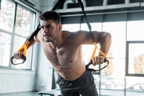 Handsome Sportsman Working Out On Suspension Trainer Free Stock Photo