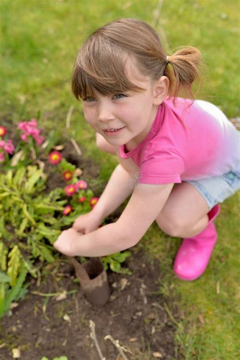 Little Girl Planting Bulbs An Flowers With A Tool In The Garden Pretty
