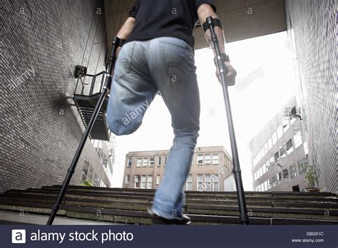 Male Amputee Walking Up Stairs With Crutches Stockfoto Lizenzfreies