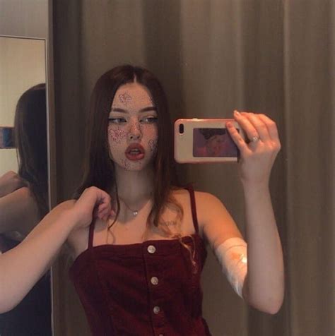 A Woman Taking A Selfie In Front Of A Mirror With Makeup On Her Face