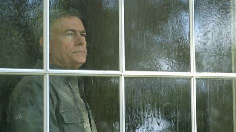 Outside View Of A Man Looking Out A Window During A Rain Storm Stock