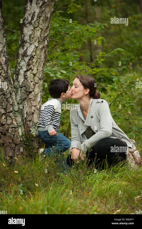 Madre E Hijo Beso En Los Bosques A Pie Para Mostrar Amor Fotografía De