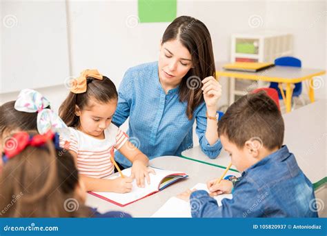 Preschool Teacher Helping Her Pupils Stock Image Image Of Latin