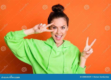 Photo Portrait Of Woman Showing Two V Signs Near Eye Isolated On Vivid Orange Colored Background