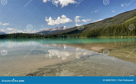 Mountains And Clouds Reflected In A Mountain Colored Lake Stock Image