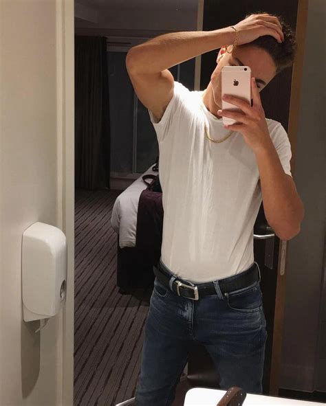A Man Taking A Selfie In The Mirror With His Cell Phone And Wearing Jeans