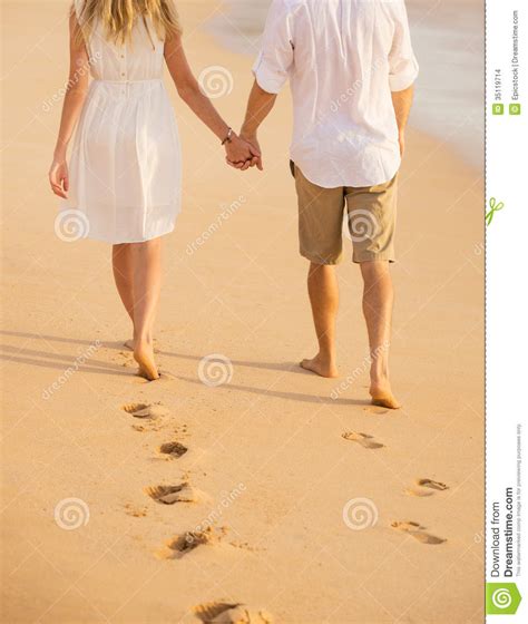 Romantic Couple Holding Hands Walking On Beach At Sunset Stock Images
