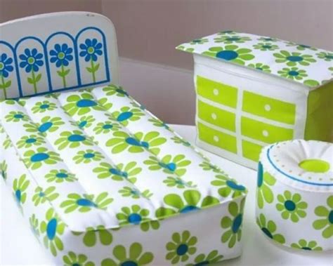 A Green And White Bed Sitting On Top Of A Table Next To A Box Filled