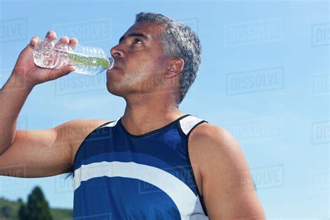 Mixed Race Man Drinking Water Bottle Stock Photo Dissolve