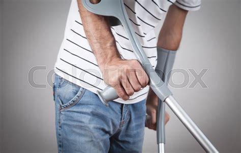 Caucasian Man With A Crutches On Grey Stock Image Colourbox