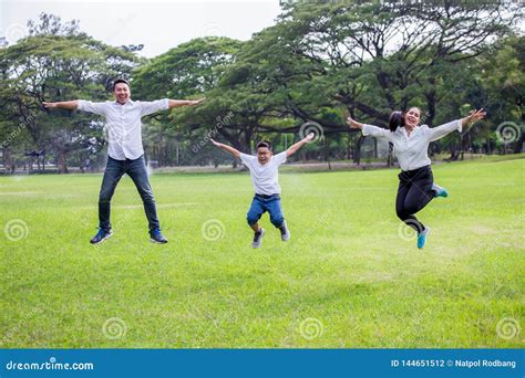 Familia Asiática Feliz Padres Y Sus Niños Saltando Junto En Parque
