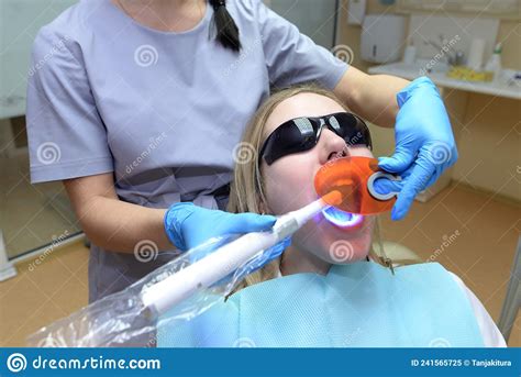 Girl Patient Wearing Protective Eyeglasses Lying On Chair In Dental Clinic Office Dentist