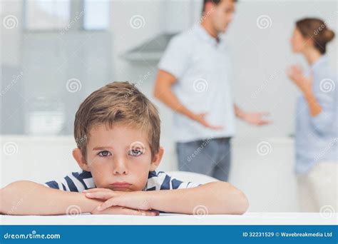 Sad Boy With Arms Folded While Parents Quarreling Royalty Free Stock