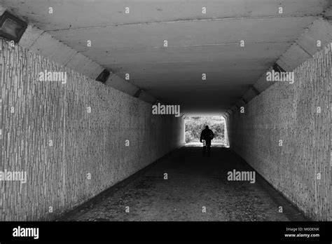 Looking Through Tunnel At Figure In Distance In Black And White Stock